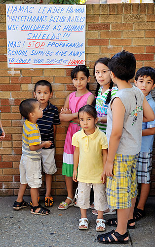 Signs of hate as mosque supporters give away school supplies