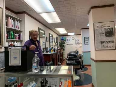 Thomas LaMarca poses in his Clark Street station barber shop