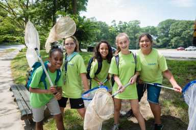 middle school girls in green tshirts with nets at green girls program
