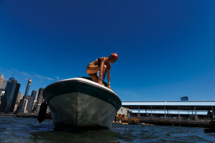 woman diving off boat at open swim