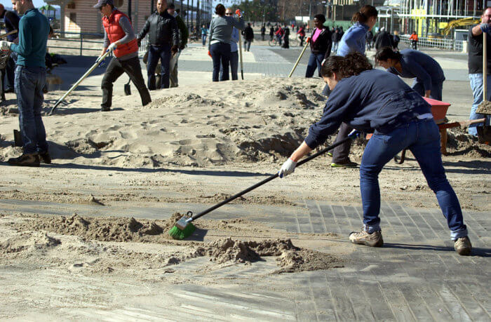 person cleaning coney boardwalk after sandy