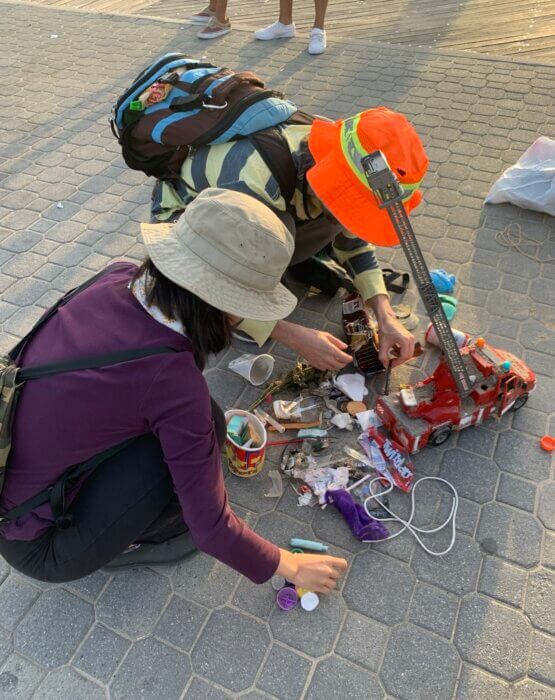 people sifting through trash after beach cleanup
