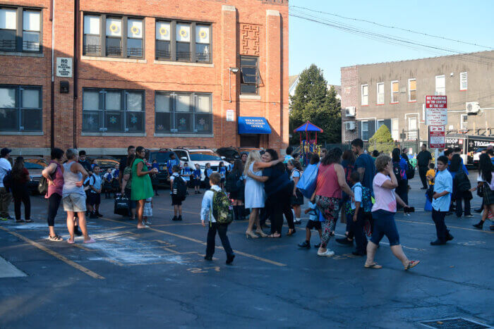 Some students give final goodbye hugs to parents as others rush to greet classmates.