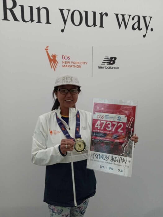woman poses with marathon bib