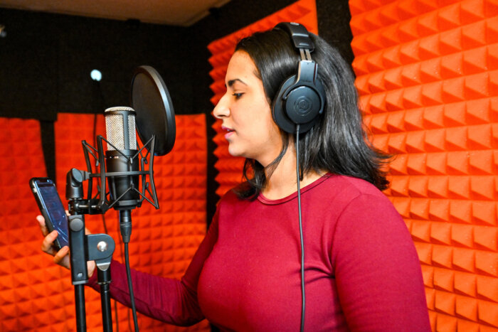 person in sound booth at red hook recreation center media lab