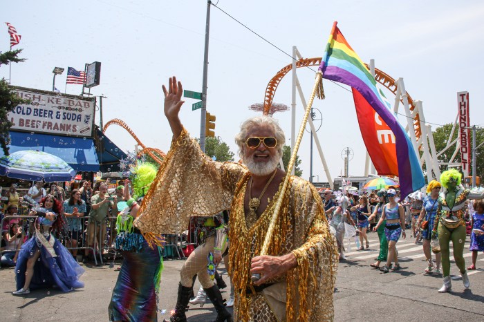 man waving flag at mermaid parade