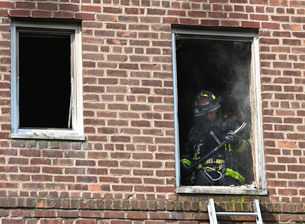 A firefighter works to overhaul an apartment at 1535 Shore Parkway.