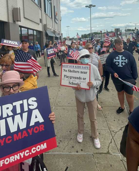 woman holding sign against shelter at rally