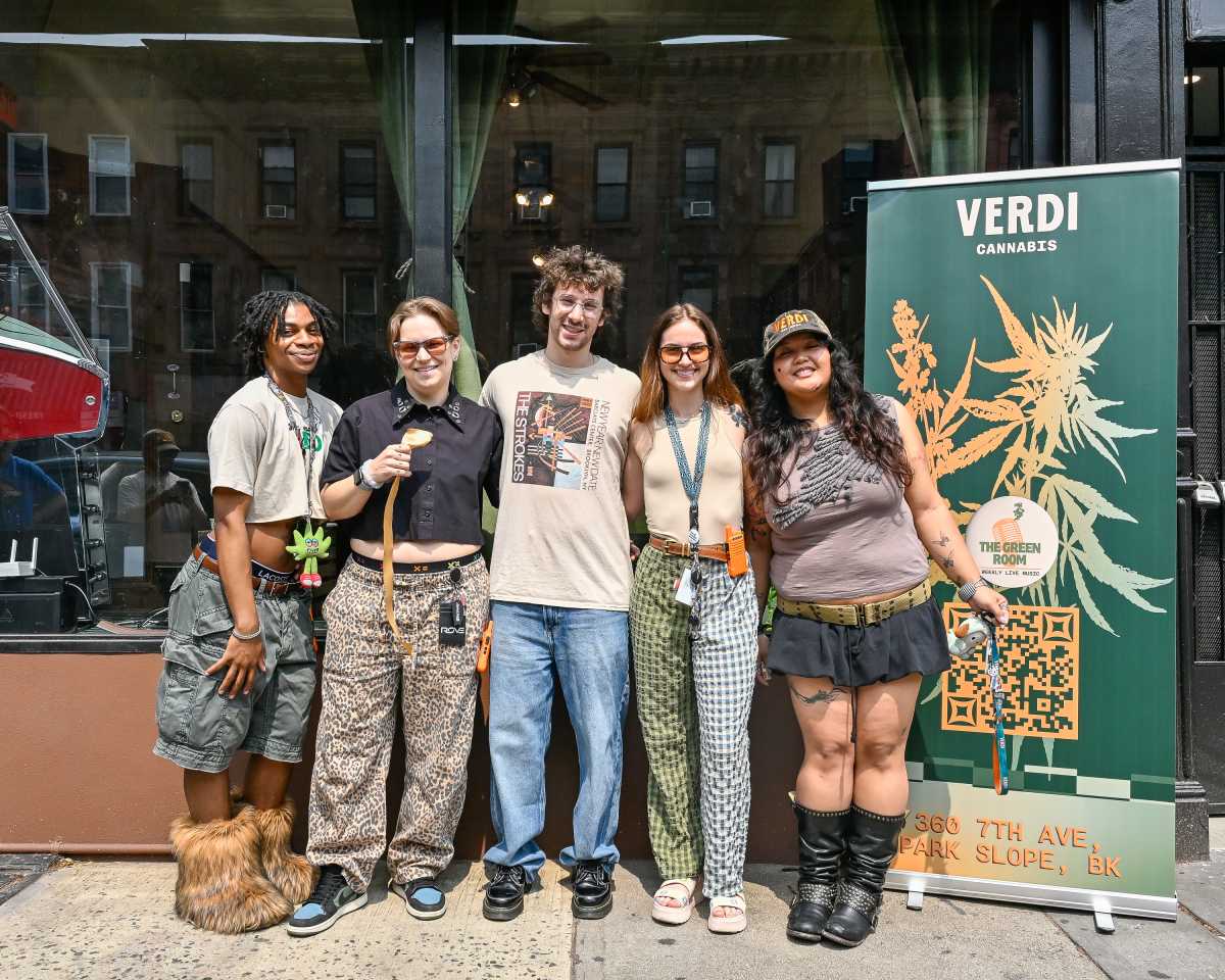 group of people people pose in front of verdi cannabis dispensary