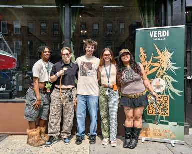 group of people people pose in front of verdi cannabis dispensary